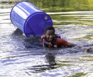 A cadet swimming in water due to the makeshift raft breaking