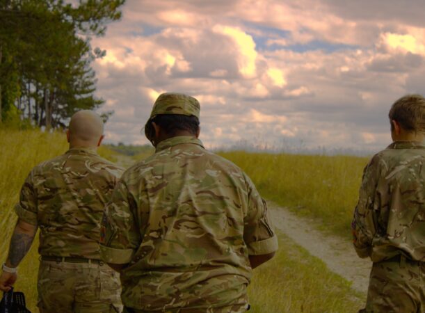 Few cadets walking on grass with a cloudy sky